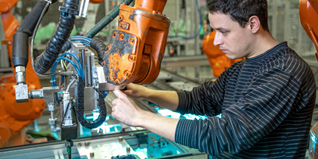 Photo montrant un opérateur travaillant dans l'industrie avec un bras robotisé