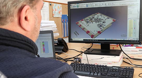 Technicien CAO Concept devant son écran utilisant un logiciel de CAO électronique